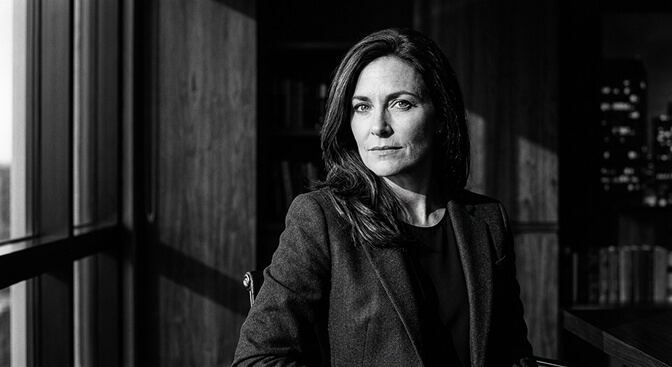 Black and white corporate headshot style with strong directional lighting and expressive face creating a powerful monochrome portrait