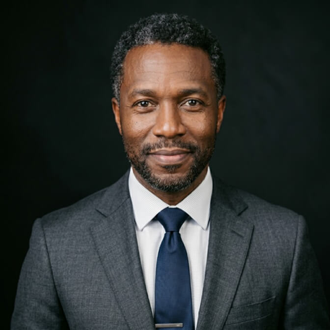 Professional headshot of a man in a dark suit that looks technically perfect yet impersonal