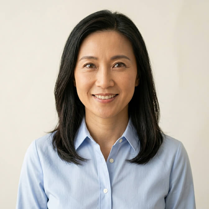 Professional headshot of a woman in a crisp solid light blue button down blouse against a clean background showing the polished put together result of the blouse formula