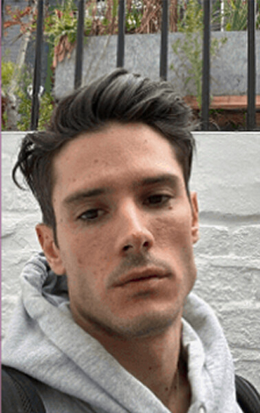 Outdoor selfie of a man in a grey hoodie with a neutral expression, taken before AI headshot generation.
