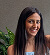 Smiling woman with long dark hair posing against a neutral background