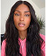 Close-up of a woman with long, wavy hair wearing a pink shirt against soft background
