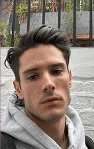 Outdoor selfie of a man in a grey hoodie with a neutral expression, taken before AI headshot generation.