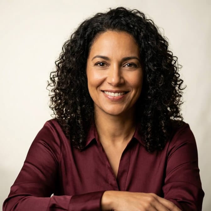 Warm, current professional headshot of a woman with a confident expression and a clean neutral background