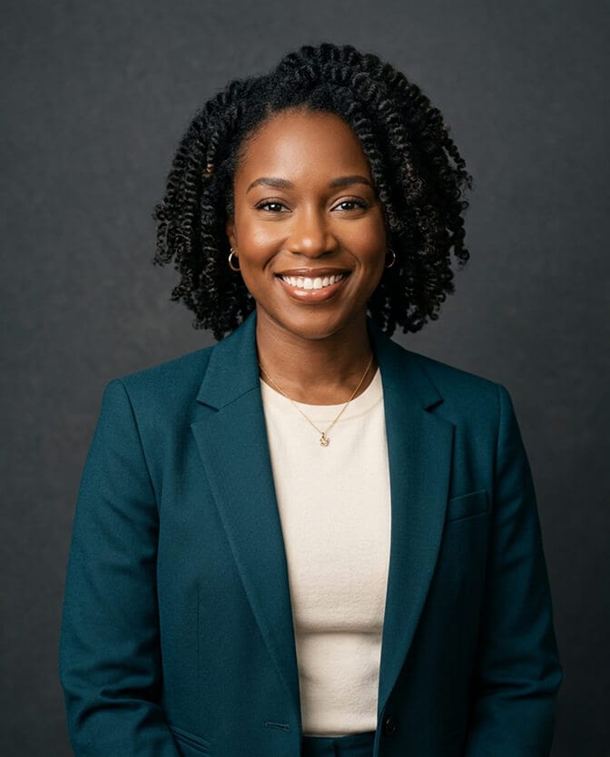 Professional AI headshot of a woman in a teal blazer and cream top against a dark background illustrating the quality output from an AI headshot plan