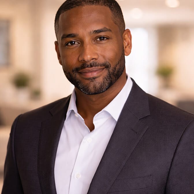 Professional AI headshot of a man in a dark blazer and white open collar shirt against a blurred office background