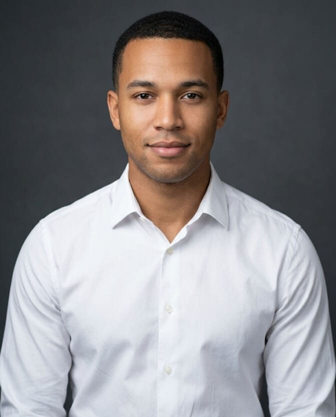 Clean first professional headshot of a recent graduate in a white shirt against a simple neutral background