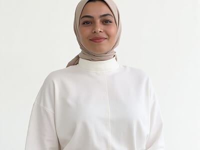 Passport photo contrast failure: woman in a white top and cream head covering against a white background, where the shoulders disappear into the backdrop