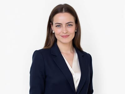 Navy blazer and white collared shirt passport photo outfit example for a woman against a plain background