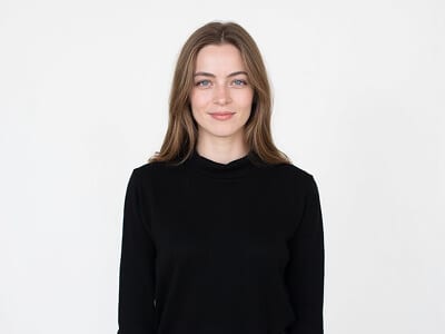 Passport photo outfit idea for a woman: plain black crew-neck top with a modest neckline against a plain white background