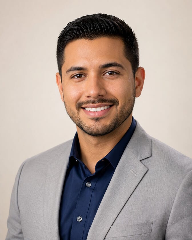 Professional AI headshot of a man in a light gray blazer and navy shirt against a soft warm background showing the natural confident look that emerges when the light, distance, and frame are right