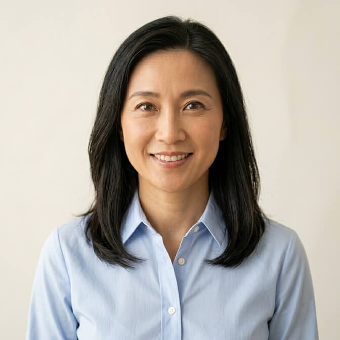 Professional headshot of a woman in a crisp solid light blue button down blouse against a clean background showing the polished put together result of the blouse formula