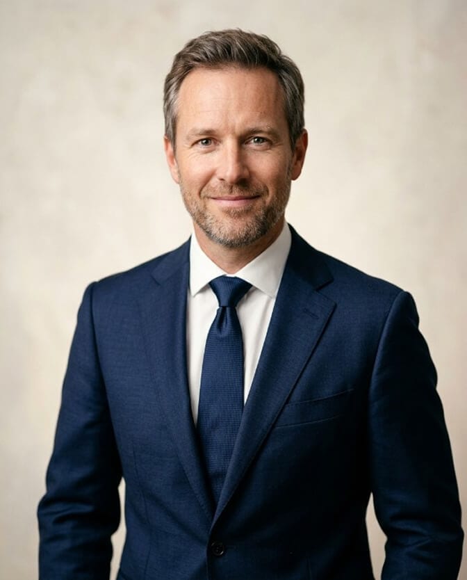 Professional headshot of a man in a navy suit, staged with intention the way every headshot is