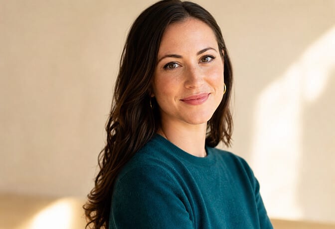 Headshot showing subtle personality through small smile distinctive accessory and pop of color