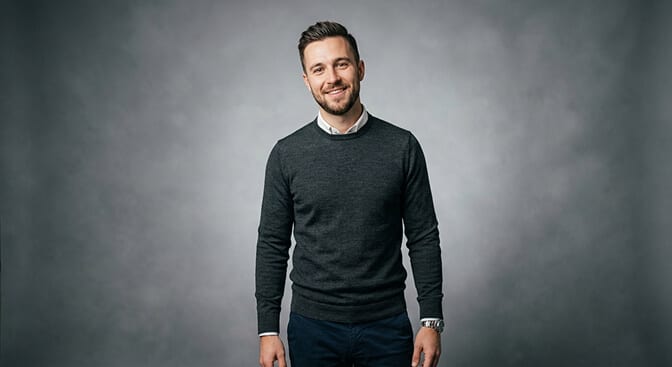 Business casual headshot style with fitted sweater or shirt clean background and relaxed professional expression