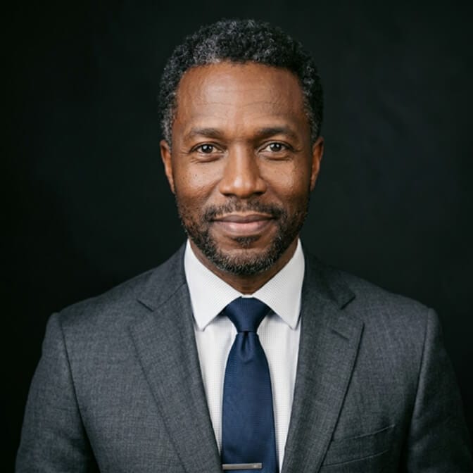 Professional headshot of a man in a dark suit that looks technically perfect yet impersonal