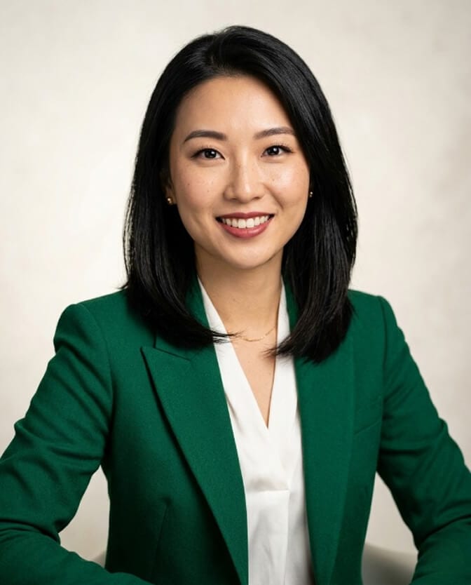 Studio-quality professional headshot of a woman in a green blazer, the kind a same-day photographer would deliver