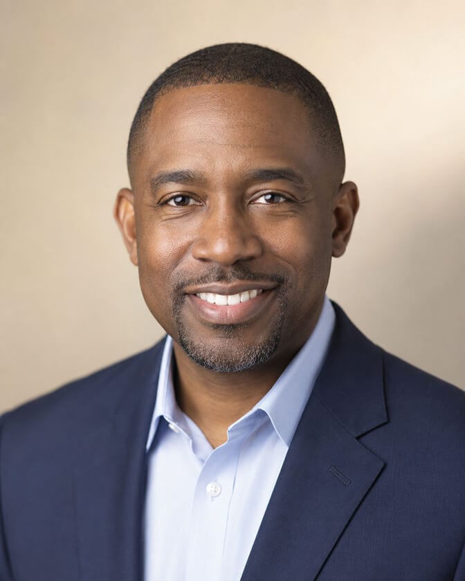 Side by side comparison of a stiff 2020 era corporate headshot with a white backdrop next to a warmer, softer, more natural 2026 standard professional headshot