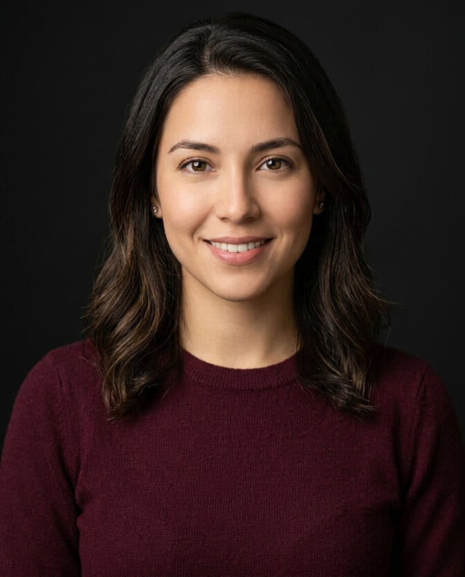 Professional headshot of a woman in a burgundy top against a contrasting background showing how a rich solid jewel tone photographs cleanly and keeps focus on the face