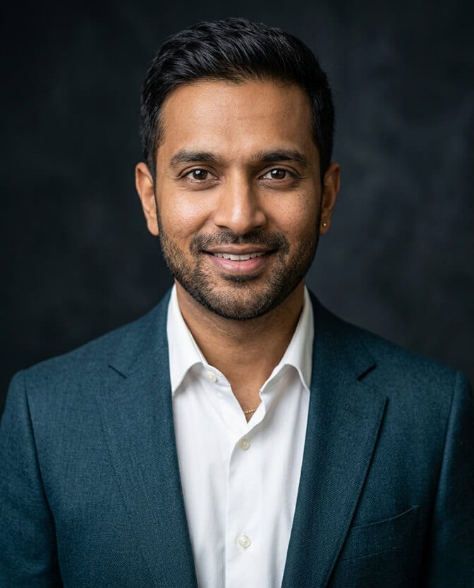 Side by side AI headshot comparison showing the same person in a light gray blazer with low contrast and a navy blazer with strong facial definition