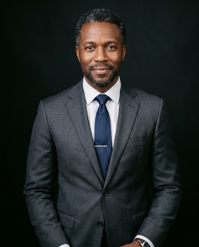 Polished professional headshot of a man with natural, realistic skin texture instead of over-retouched plastic skin