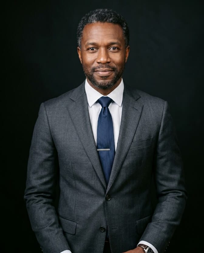 Polished professional headshot of a man with natural, realistic skin texture instead of over-retouched plastic skin