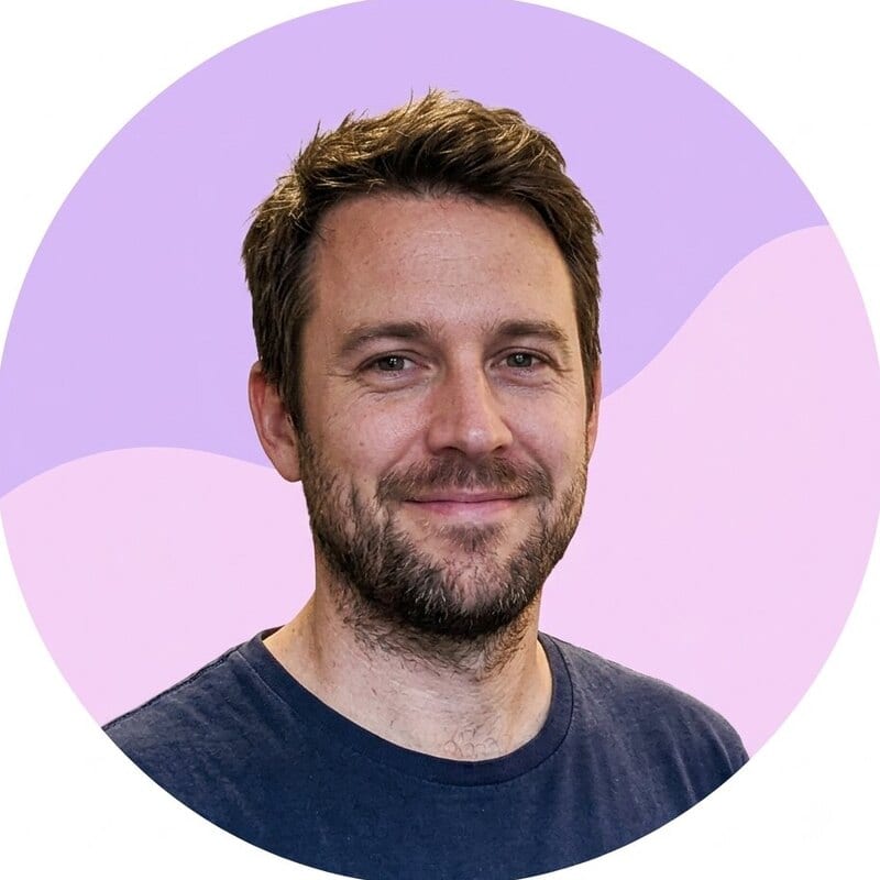 After using the profile picture maker: the same man as a circular profile picture, with the office background removed and replaced by a flat lilac and pink graphic, and his face centred in the frame.